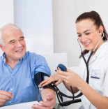 skilled nurse measuring elder man blood pressure