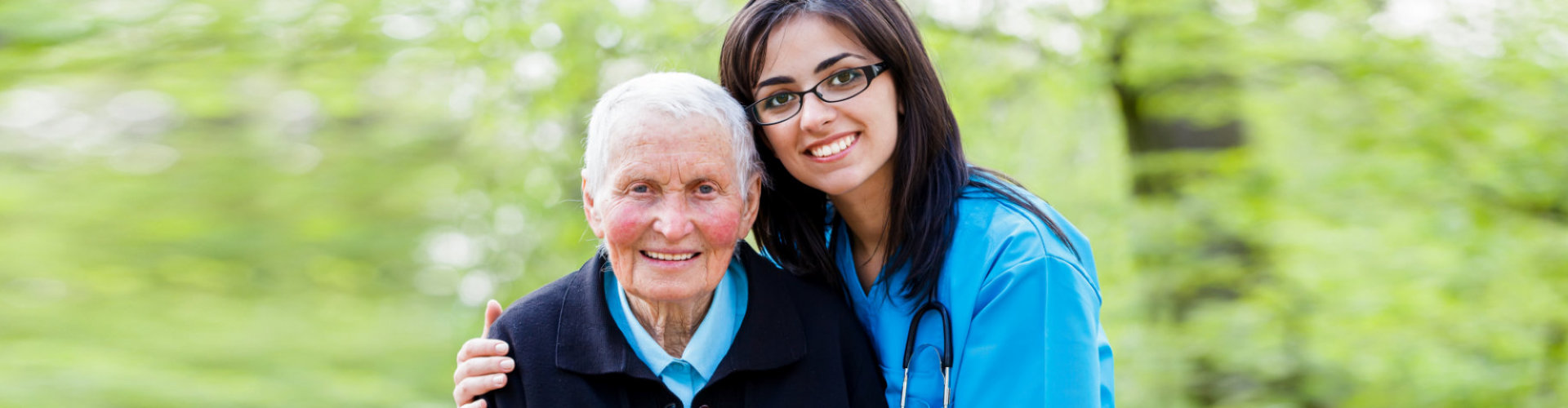 elder woman smiling with caregiver beside her
